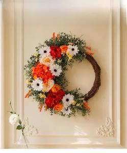 Close-up of bohemian artificial flower wreath with silk roses on natural rattan base