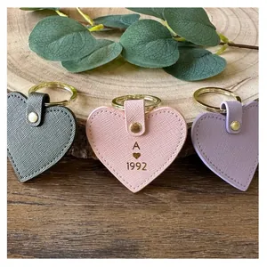 Handmade leather heart keychains in pink, purple and grey with gold hardware