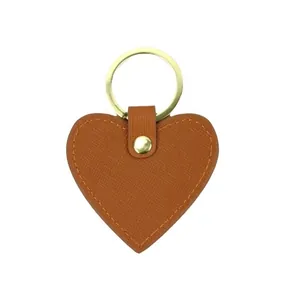 Brown heart-shaped leather keychain with lychee texture and gold metal ring