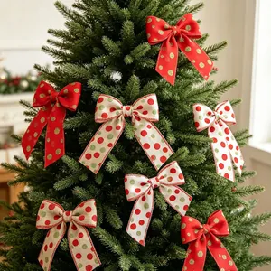 Close-up of red and linen Christmas bows with dots hanging on evergreen tree branches