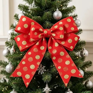 Detailed view of a red velvet Christmas bow with gold glitter dots on a festive tree
