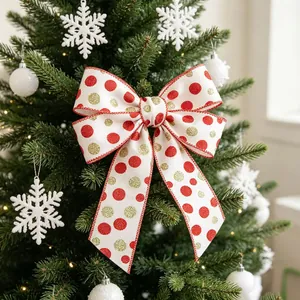 Close-up of a white linen Christmas bow with red and gold glitter dots on a tree branch
