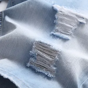 Men's light blue distressed denim shorts with ripped holes and frayed edges in a loose fit