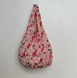 Detail of expandable bubble tote bag featuring pink floral patterns and textured fabric