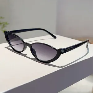 Fashionable black cat-eye sunglasses with gradient lenses on a white display stand