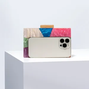 Macro view of color-block acrylic evening clutch showing its capacity for a smartphone