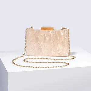 Detail of beige marble acrylic evening clutch bag with gold chain and push clasp