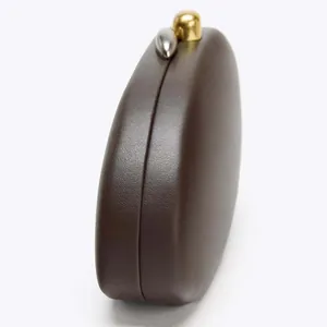 Side view showing the thickness and pebbled leather texture of the brown clutch bag