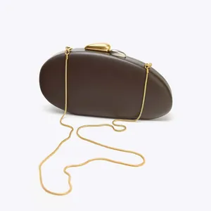 Macro shot of dark brown pebble clutch with silver and gold metallic stone clasp