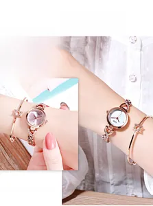 Détail macro d'une montre à quartz or rose avec diamants et bracelet étoile assorti