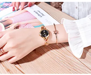Élégante montre à quartz dorée avec cadran noir serti de diamants et bracelet étoile assorti