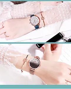 Close-up of elegant starry dial watch with magnetic blue mesh strap and accessories