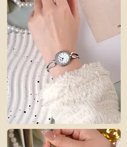 Close-up of elegant silver quartz watch with rhinestone bezel and hollow link bracelet