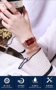 Dettaglio dell'orologio in oro rosa con quadrante rosso, bracciale e anello a farfalla