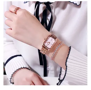 Vista ravvicinata dell'orologio ottagonale in oro rosa e del set di gioielli sul polso