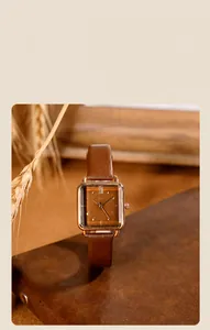 Reloj cuadrado de oro rosa con correa de cuero marrón y números romanos