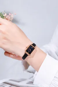 Chic women's rectangular quartz watch with starry blue dial and black leather strap worn on wrist