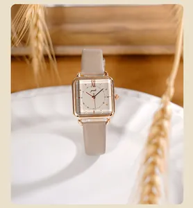 Primer plano de reloj cuadrado vintage con correa de cuero marrón y caja de oro rosa
