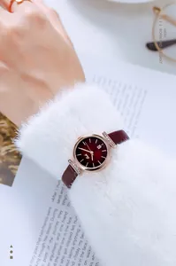 Detail of Gedi rose gold watch featuring a deep red dial and diamond-set case