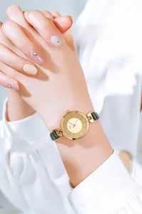 Elegant gold watch for women featuring a minimalist dial and a slim green leather strap