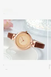 Detail view of a rose gold quartz watch with champagne dial and brown leather strap