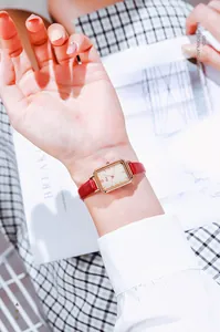 Close-up of Gedi rectangular gold quartz watch with a sleek red leather strap