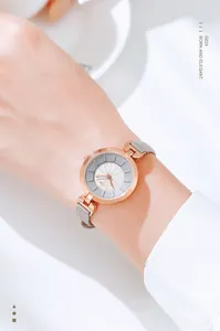 Elegant rose gold quartz watch with slim grey leather strap shown on female wrist