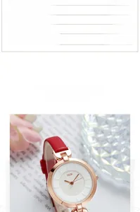 Detail view of GEDI fashion watch with rose gold case and red leather strap on book background