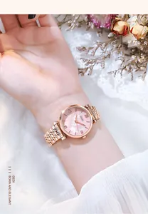 Gros plan d'une montre élégante en or rose avec cadran en nacre rose au poignet