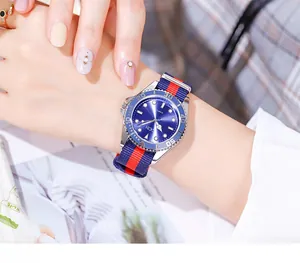 Gros plan d'une montre GEDI pour femme avec cadran bleu et bracelet en tissu rayé au poignet