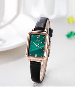 Detail of rectangular rose gold watch with green malachite dial and black leather strap