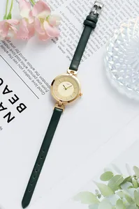 Detail of GEDI women watch with gold dial and slim dark green leather strap