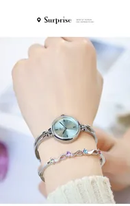 Close-up of elegant silver quartz watch with mint green dial and colorful gemstone bracelet