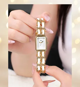 Detailed macro of a gold rectangular women's watch with elegant white leather chain strap