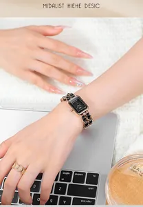 Detail of luxury rectangular quartz watch with gold chain leather strap and heart ring