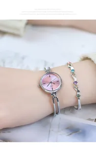 Close-up of pink dial JW watch paired with a colorful gemstone silver bracelet on wrist