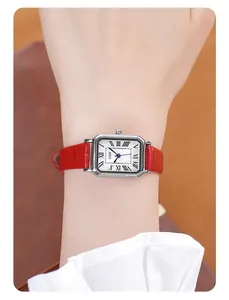 Close-up of retro silver rectangular watch with red leather strap on a female wrist