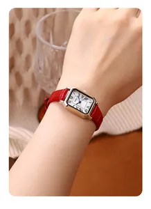 Close-up of retro rectangular watch with rose gold case and red embossed leather strap