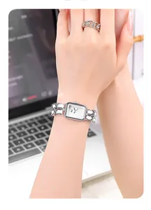 Detail view of square silver watch with chain leather strap and matching chain ring