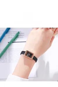 Détail d'une montre à quartz pour femme avec boîtier or rose et bracelet en cuir noir