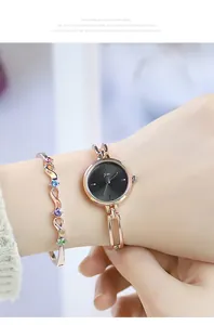 Close-up of rose gold watch and matching wavy bracelet with colorful crystals