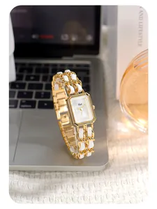Detail of luxury gold rectangular quartz watch with woven leather and metal chain strap