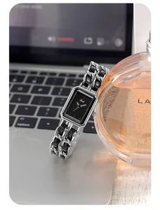 Detail of elegant rectangular black dial watch with silver interwoven chain strap
