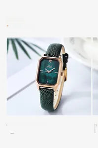 Detail of square rose gold watch featuring a vintage green marble dial and textured strap