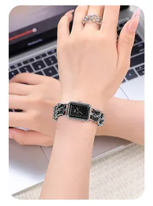 Detail of Gedi rectangular watch with leather chain strap while using a laptop