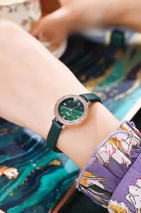 Détail de lunette or rose avec strass blancs et cadran à motif de malachite verte