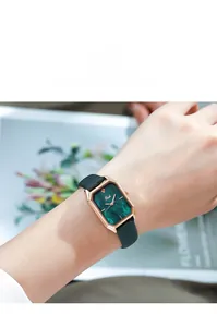 Elegant rose gold square watch with green malachite dial on model's wrist
