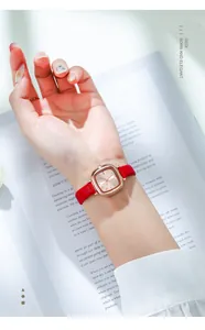 Nahaufnahme der GEDI Vintage-Uhr mit rotem Lederarmband und roségoldenem Gehäuse auf Buch