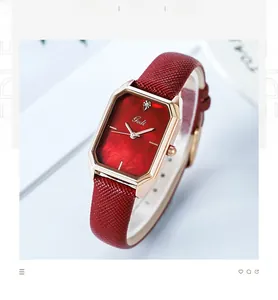 Macro shot of rose gold rectangular watch case with red sunburst dial and leather strap