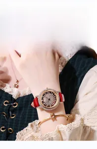 Vue macro montre luxe femme avec bracelet en cuir rouge et cadran serti de diamants fins